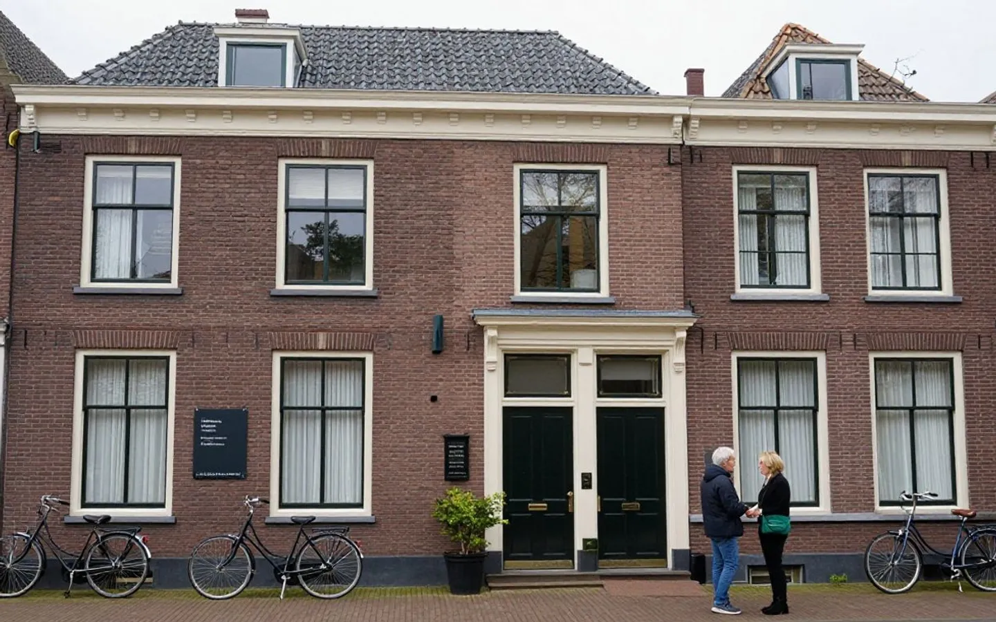 Een woonblok waar in verschillende ramen licht brandt.